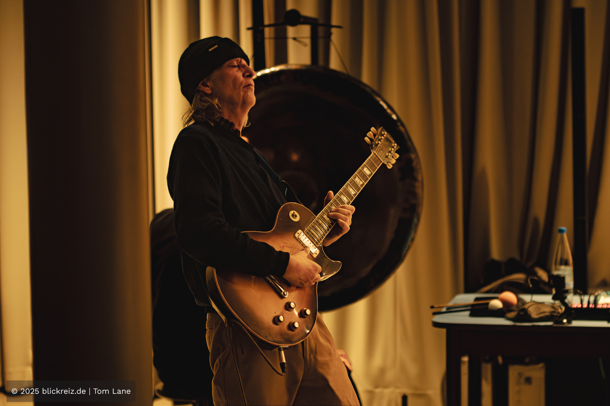 Dominik von Senger spielt konzentriert Gitarre während einer Improsession im Filmhaus Köln, festgehalten in warmem Bühnenlicht.