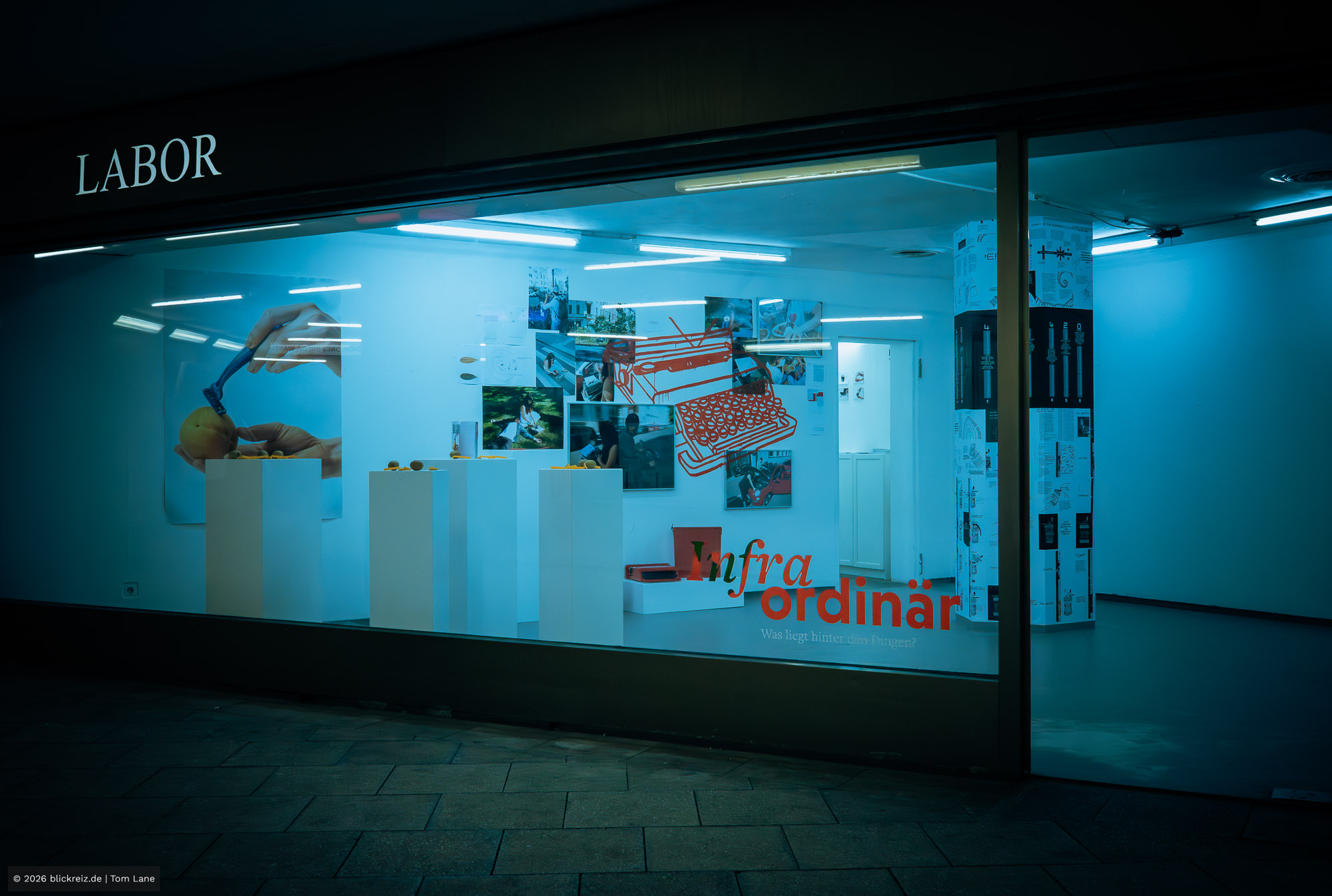 Blick von außen ins LABOR Ebertplatz: „Infraordinär“ leuchtet in der Passage, fotografiert in Köln mit urbanem Charakter.